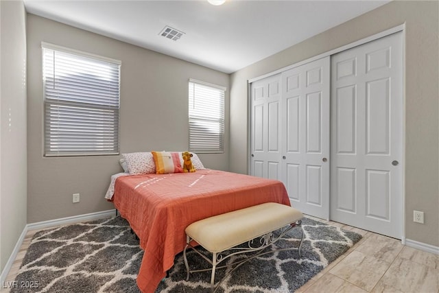 bedroom with baseboards, visible vents, and a closet