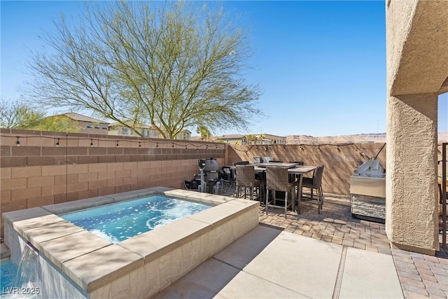 view of pool featuring a patio, outdoor dining area, an outdoor kitchen, a fenced backyard, and an in ground hot tub