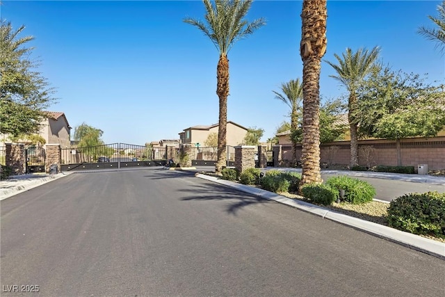 view of street featuring a residential view, a gate, curbs, and a gated entry