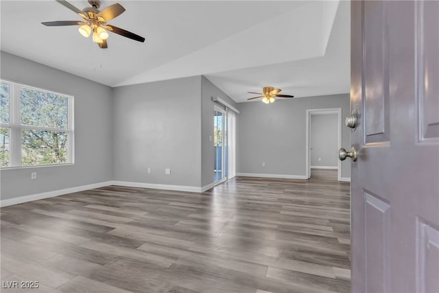 unfurnished room with ceiling fan, baseboards, vaulted ceiling, and wood finished floors