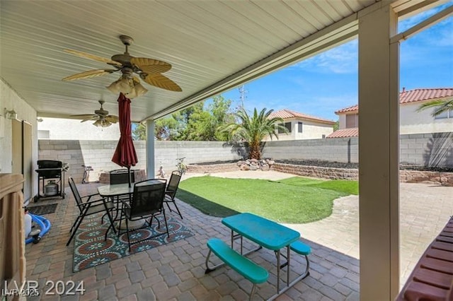 view of patio featuring a fenced backyard, a grill, outdoor dining area, and a ceiling fan