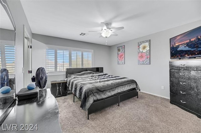 carpeted bedroom with baseboards, visible vents, and a ceiling fan