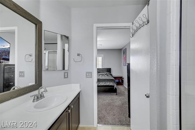 ensuite bathroom with a shower with door, vanity, and ensuite bathroom