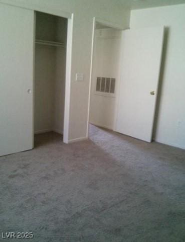 unfurnished bedroom featuring a closet, carpet flooring, and visible vents