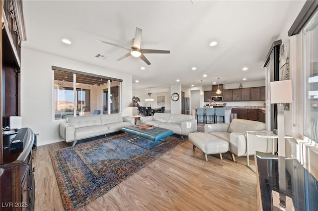 living room with recessed lighting, a ceiling fan, baseboards, visible vents, and light wood-style floors