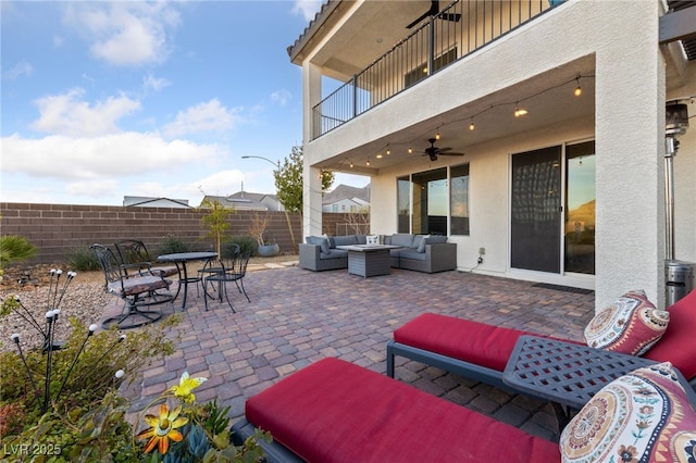 view of patio / terrace with ceiling fan, a balcony, an outdoor hangout area, fence, and outdoor dining space