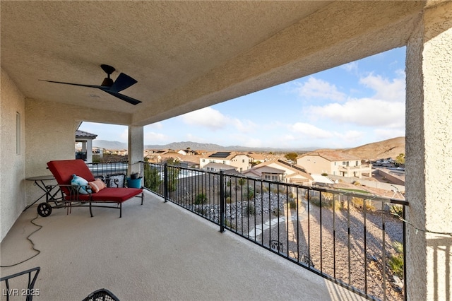 balcony featuring ceiling fan, a residential view, and a mountain view