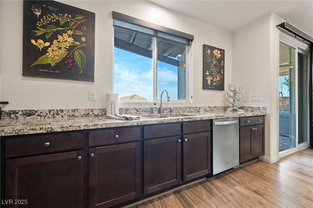 kitchen with a sink, dark brown cabinetry, light wood-type flooring, and stainless steel dishwasher