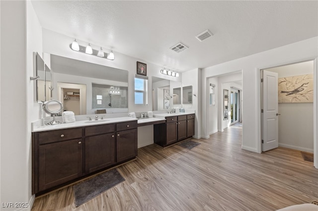 full bathroom with visible vents, a sink, and wood finished floors