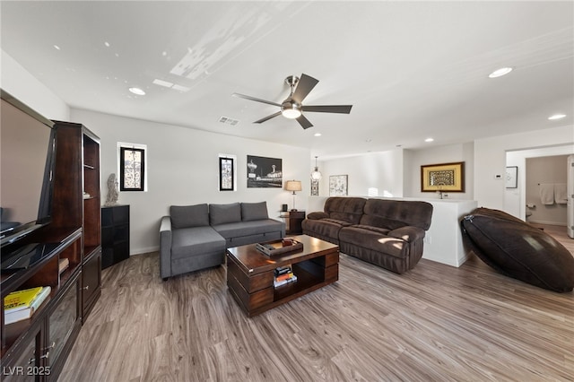 living room with baseboards, light wood-type flooring, visible vents, and recessed lighting