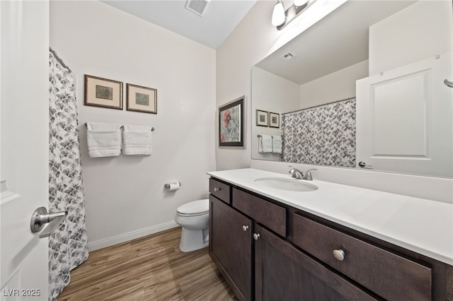 full bathroom with visible vents, toilet, vanity, wood finished floors, and baseboards