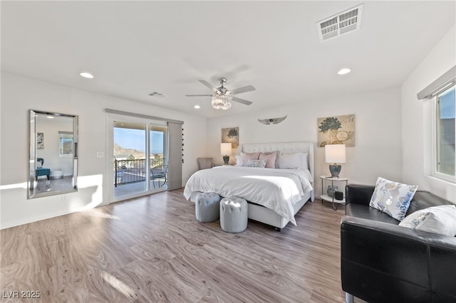 bedroom featuring access to outside, visible vents, and wood finished floors