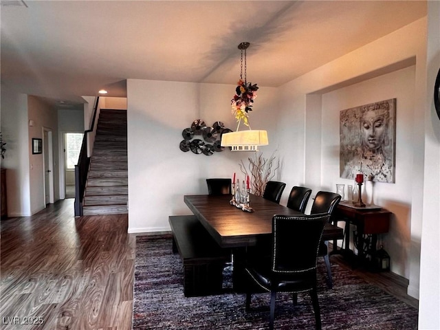 dining area with baseboards, stairway, and wood finished floors