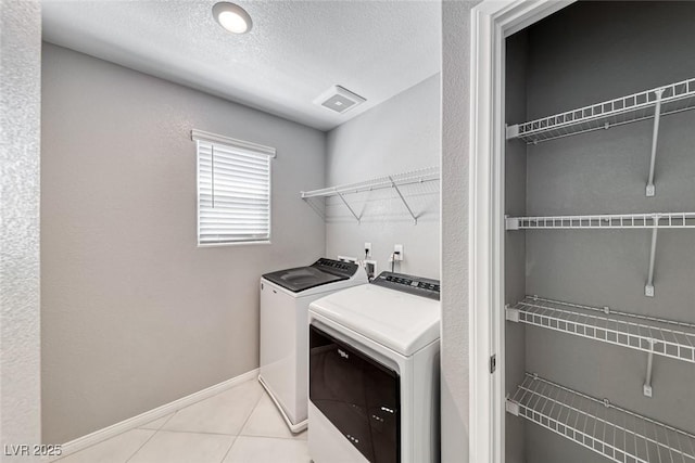 laundry room with laundry area, baseboards, visible vents, independent washer and dryer, and a textured ceiling