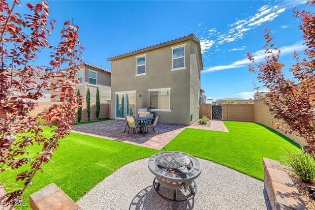 back of house with a patio, stucco siding, a lawn, a fenced backyard, and a fire pit