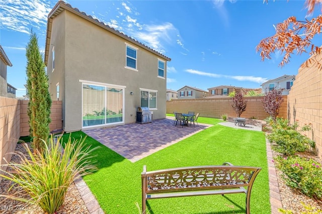 back of house featuring a patio area, a fenced backyard, a lawn, and stucco siding