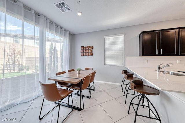 dining area featuring light tile patterned floors, baseboards, and visible vents