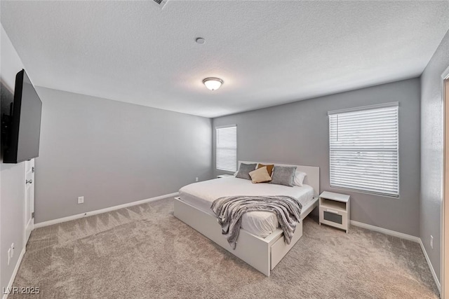 carpeted bedroom featuring baseboards and a textured ceiling