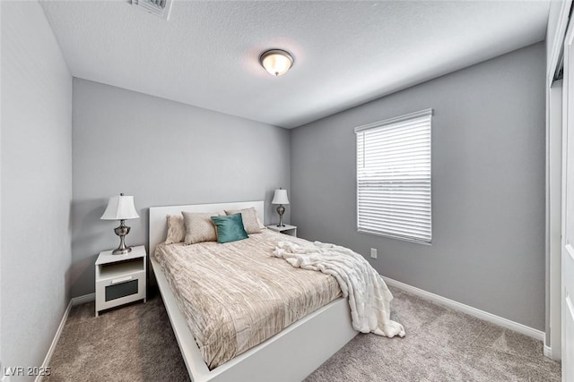 bedroom with visible vents, baseboards, dark colored carpet, and a textured ceiling