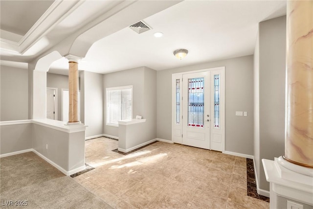 entrance foyer with visible vents, arched walkways, baseboards, and ornate columns