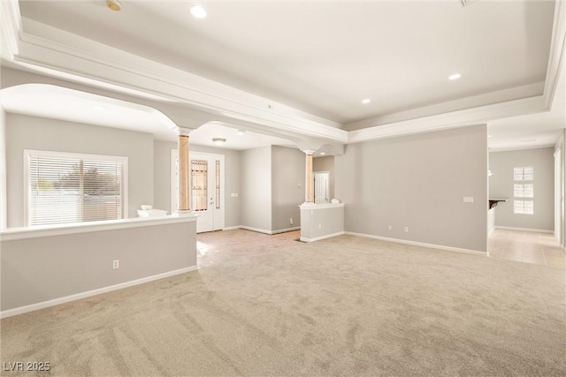 carpeted spare room featuring baseboards, a tray ceiling, recessed lighting, and decorative columns