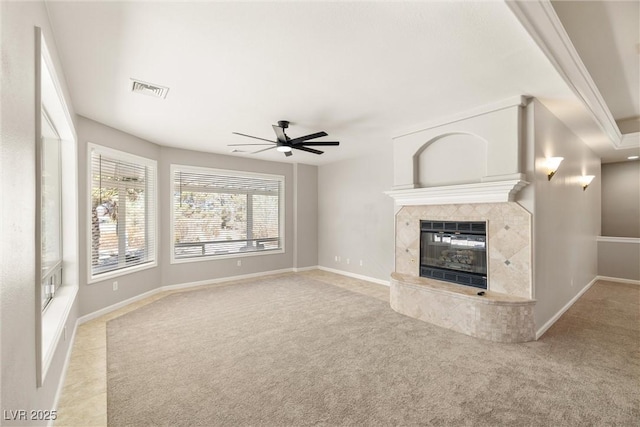 unfurnished living room featuring a fireplace, carpet floors, ceiling fan, and visible vents