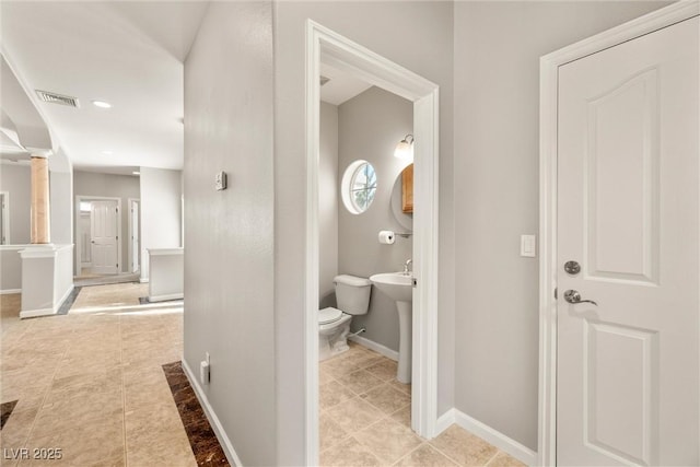 bathroom with toilet, tile patterned flooring, baseboards, and visible vents