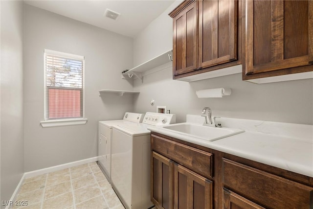 laundry room featuring visible vents, baseboards, a sink, cabinet space, and washer and clothes dryer