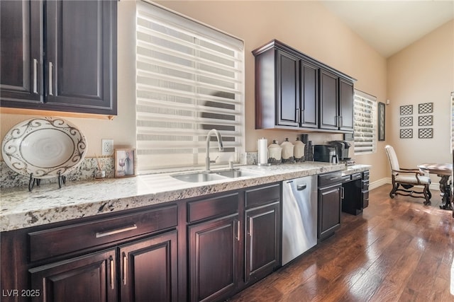 kitchen with dark wood-style floors, stainless steel dishwasher, vaulted ceiling, a sink, and baseboards