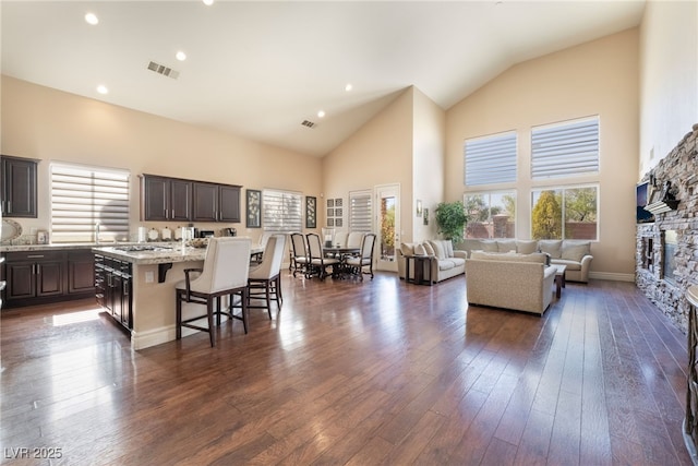 kitchen with a fireplace, visible vents, a breakfast bar, and dark wood finished floors