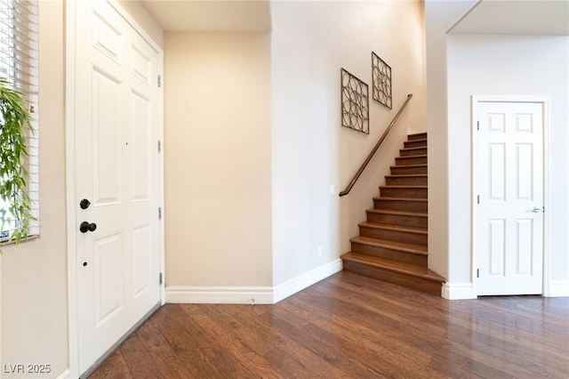 foyer featuring stairs, baseboards, and wood finished floors