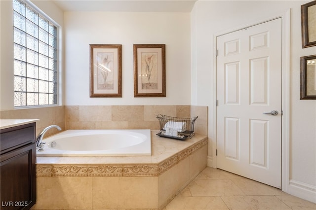 bathroom with a healthy amount of sunlight, a bath, and vanity