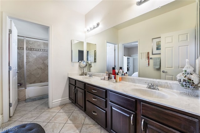 bathroom with tile patterned flooring, enclosed tub / shower combo, a sink, and double vanity