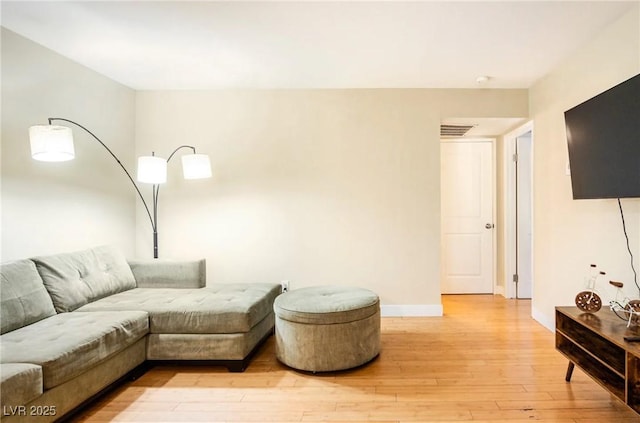 living room featuring baseboards, visible vents, and light wood-style floors