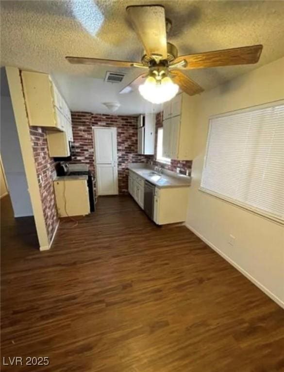 kitchen featuring dark wood-style floors, visible vents, a sink, and a textured ceiling