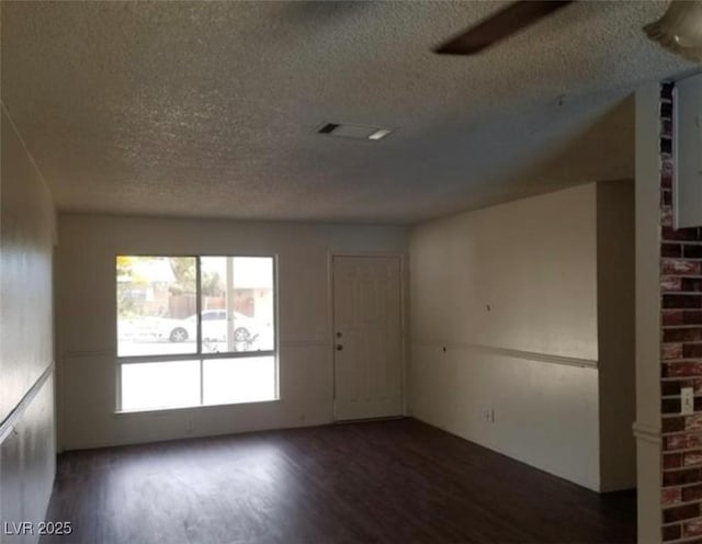 spare room featuring visible vents, a textured ceiling, and wood finished floors