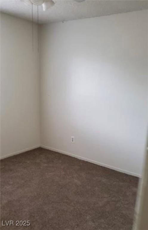 carpeted spare room with a textured ceiling and baseboards