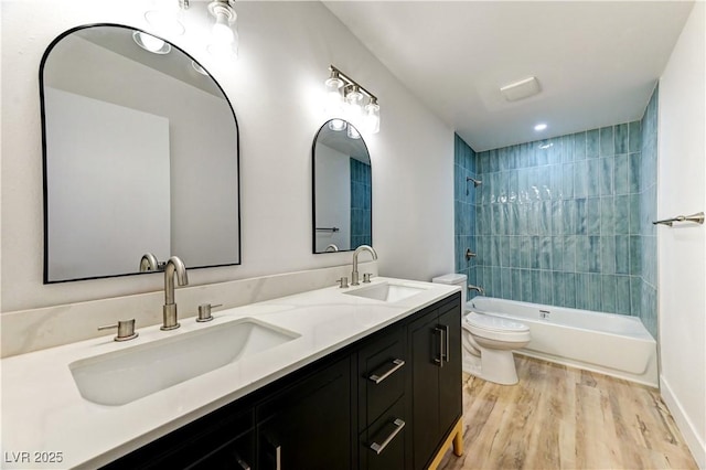 full bathroom featuring toilet,  shower combination, a sink, and wood finished floors