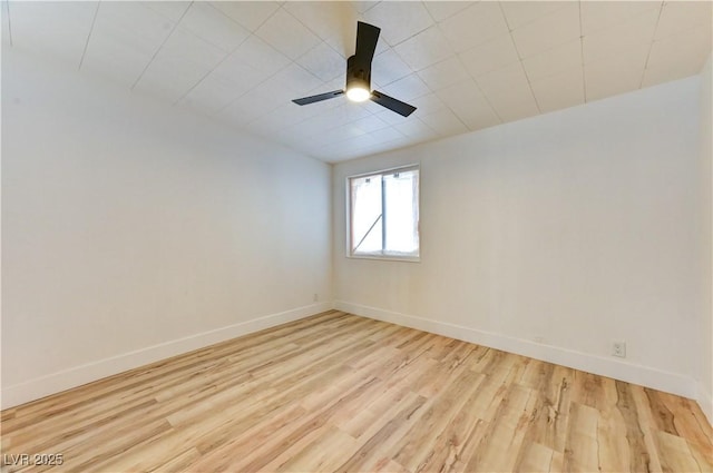 spare room featuring ceiling fan, baseboards, and wood finished floors