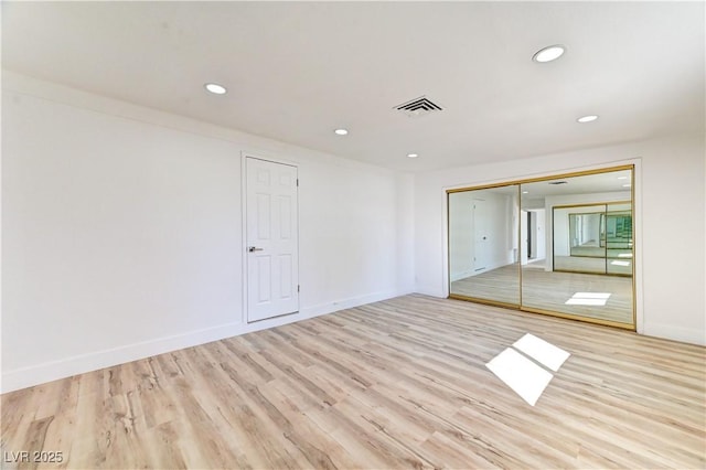 unfurnished bedroom with recessed lighting, a closet, visible vents, light wood-type flooring, and baseboards