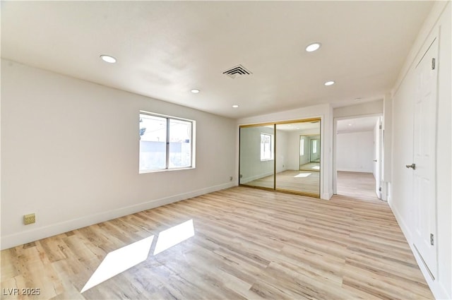 unfurnished bedroom with recessed lighting, light wood-style flooring, and baseboards