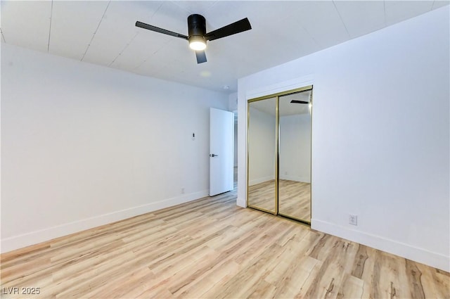 unfurnished bedroom featuring ceiling fan, a closet, wood finished floors, and baseboards