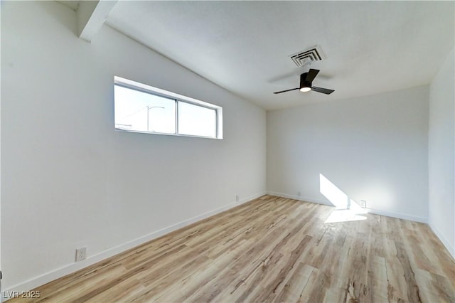 empty room with baseboards, visible vents, ceiling fan, wood finished floors, and beamed ceiling