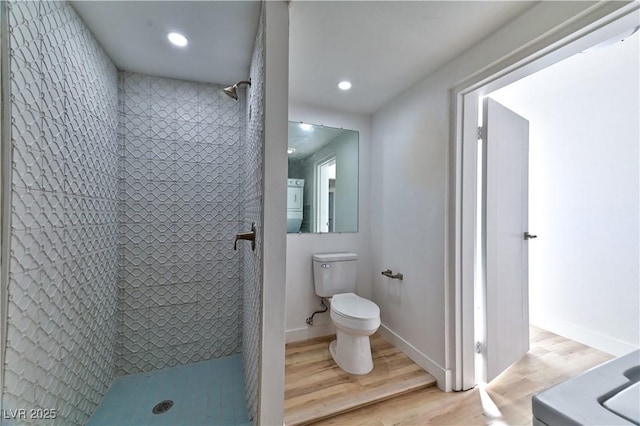 bathroom with toilet, recessed lighting, wood finished floors, baseboards, and a shower stall