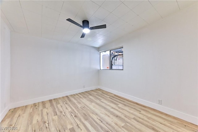 empty room with ceiling fan, baseboards, and wood finished floors