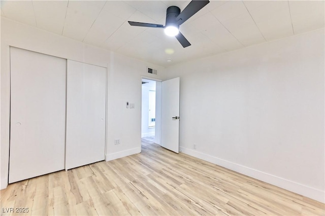 unfurnished bedroom with baseboards, visible vents, a ceiling fan, light wood-style flooring, and a closet