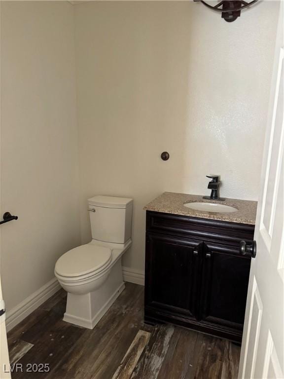 bathroom with vanity, toilet, and wood finished floors