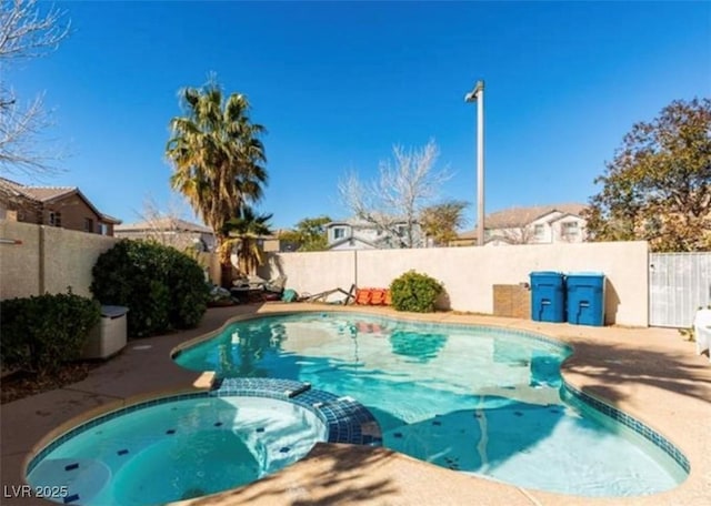 view of swimming pool with a pool with connected hot tub and a fenced backyard