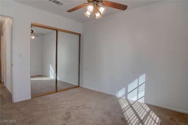 unfurnished bedroom with baseboards, carpet, visible vents, and a closet