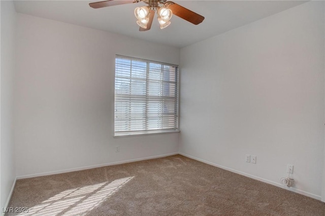 carpeted spare room featuring a ceiling fan and baseboards